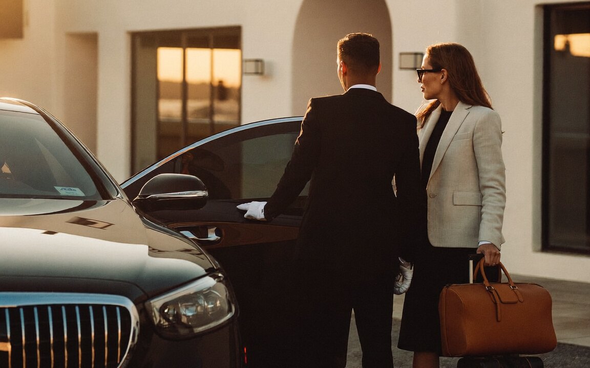 Chauffeur greeting guests beside a black Mercedes-Benz S-Class in Mykonos