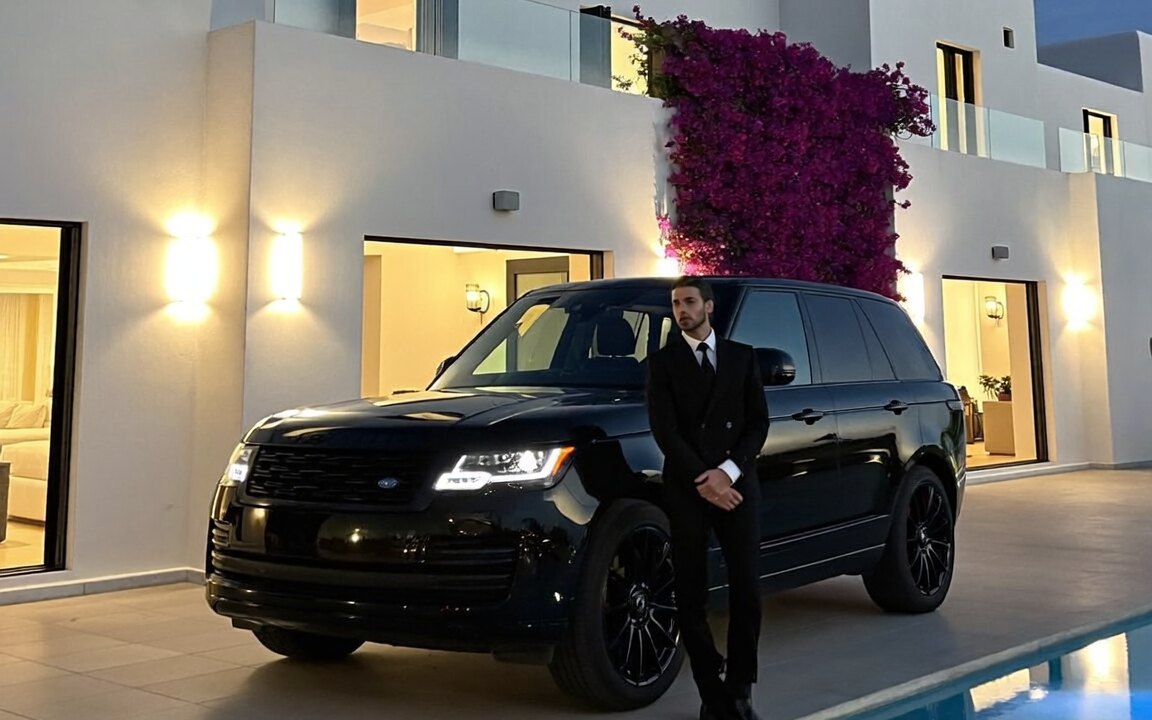 Chauffeur beside a black Range Rover at a Mykonos villa