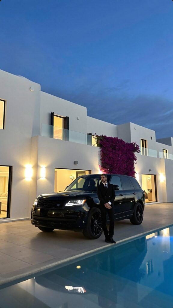 Chauffeur beside a black Range Rover at a Mykonos villa